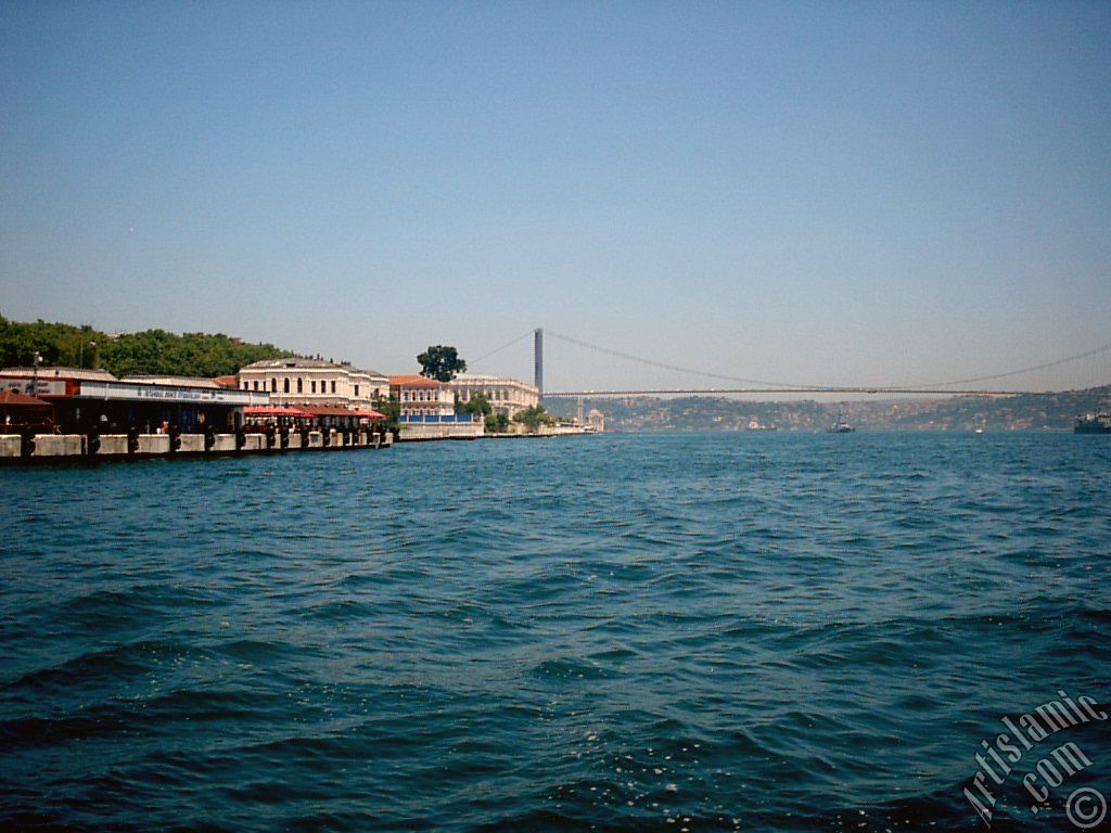 View of the Ciragan Palace and the Bosphorus Bridge from the shore of Besiktas district of Istanbul city in Turkey.
