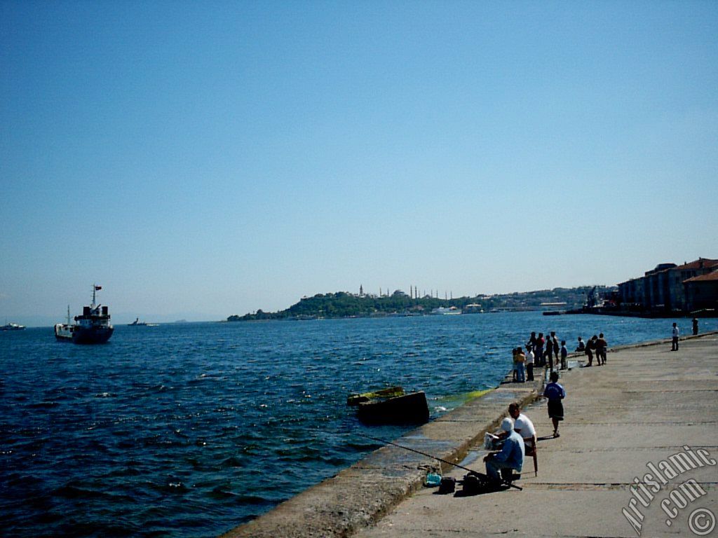 View of fishing people, Sarayburnu coast, Topkapi Palace, Ayasofya Mosque (Hagia Sophia) and Sultan Ahmet Mosque (Blue Mosque) from a park at Kabatas shore in Istanbul city of Turkey.
